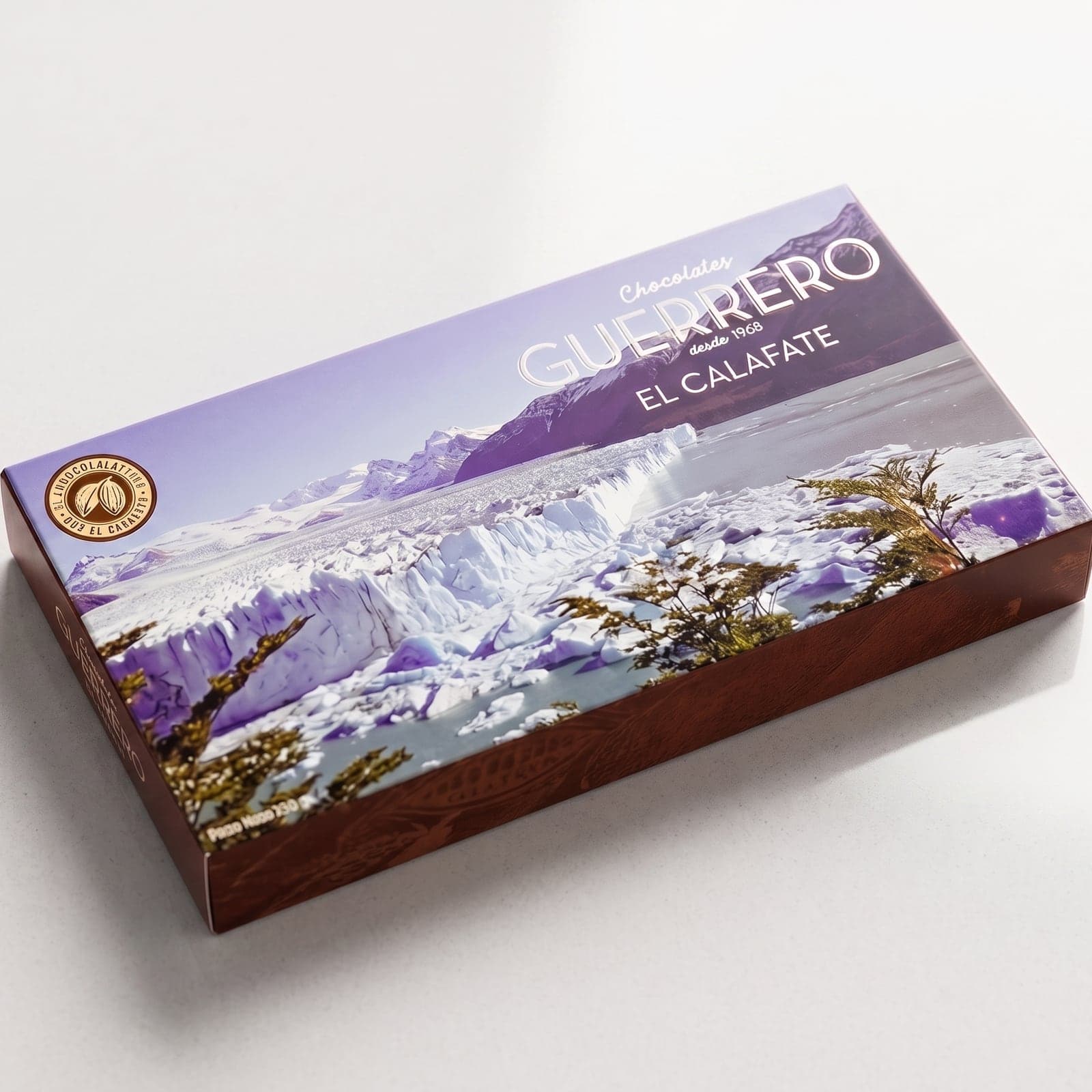 Caja cerrada del surtido de chocolates artesanales de 1/4 kg, apoyada, con el Glaciar Perito Moreno en la tapa